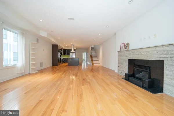 a big room with wooden floor and a fireplace