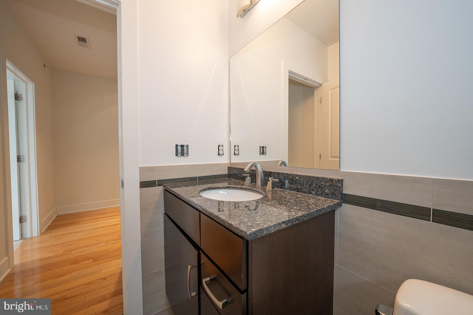 110 Naudain Street, Unit 4 Philadelphia, PA 19147 - Photo 25 of 48 a bathroom with a granite countertop sink and a mirror