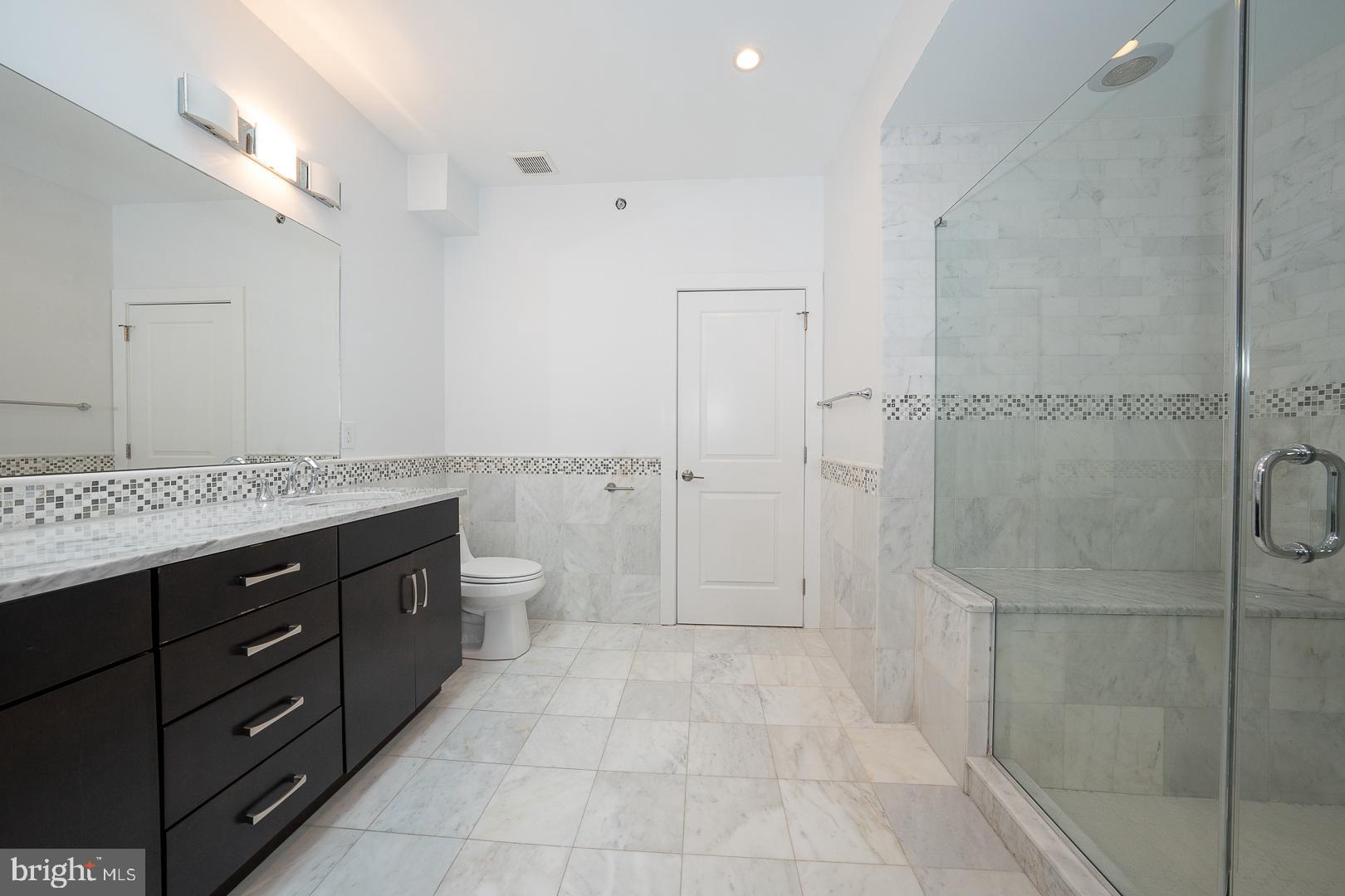 110 Naudain Street, Unit 4 Philadelphia, PA 19147 - Photo 29 of 45 a spacious bathroom with a granite countertop sink a toilet and shower