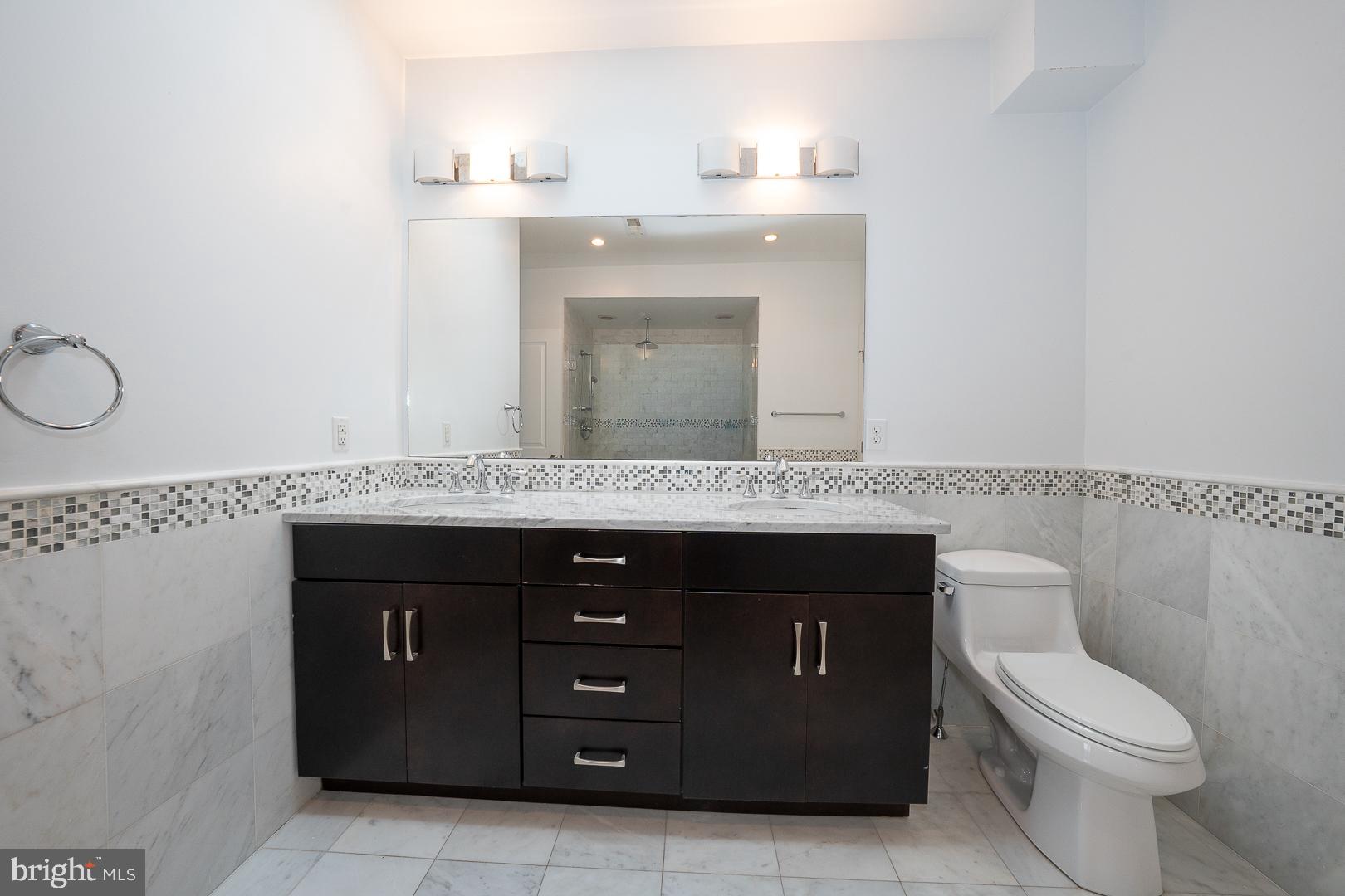 110 Naudain Street, Unit 4 Philadelphia, PA 19147 - Photo 30 of 45 a bathroom with a granite countertop sink vanity and mirror