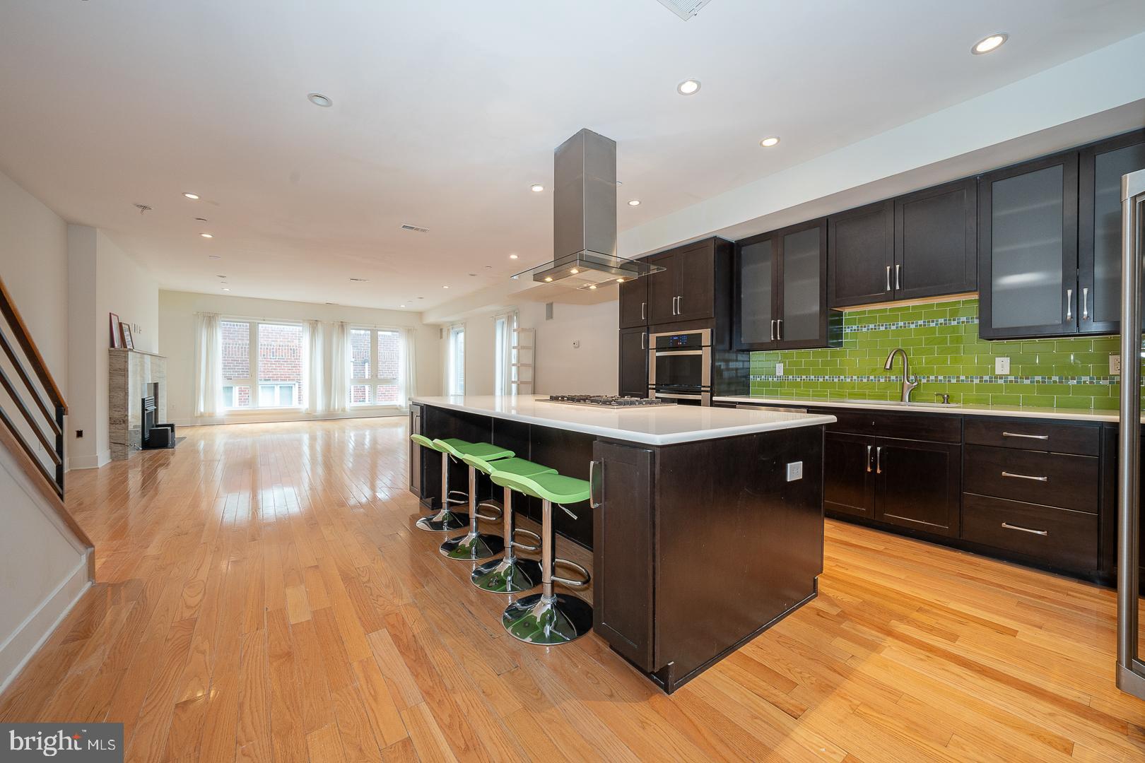 110 Naudain Street, Unit 4 Philadelphia, PA 19147 - Photo 4 of 48 a kitchen with stainless steel appliances granite countertop a refrigerator a sink dishwasher a stove and a dining table with wooden floor