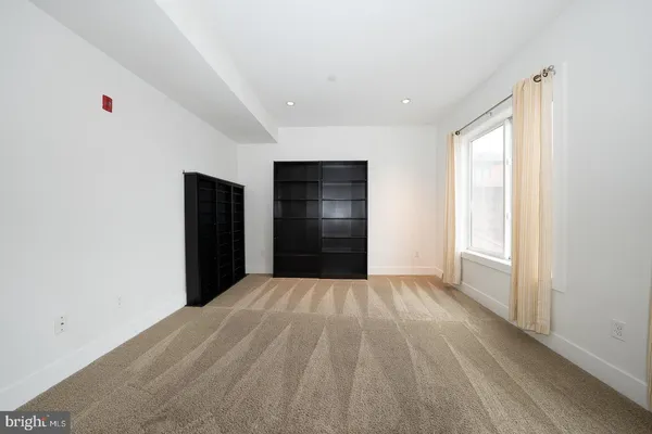 a view of an empty room with a window and closet