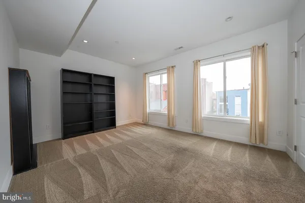 a view of an empty room with a fireplace and a window
