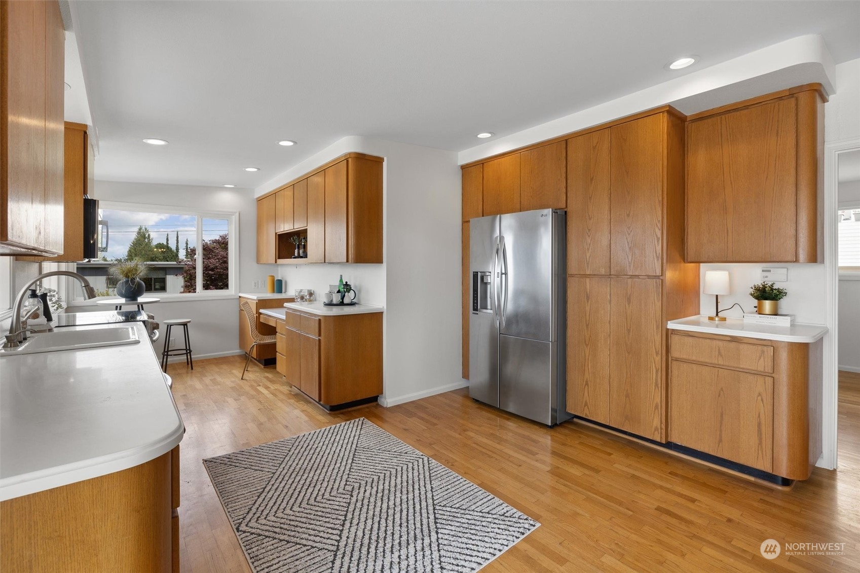 730 Laurel Street Edmonds, WA 98020 - Photo 9 of 36 a kitchen with stainless steel appliances granite countertop a refrigerator a sink a stove top oven a dining table and chairs with wooden floor