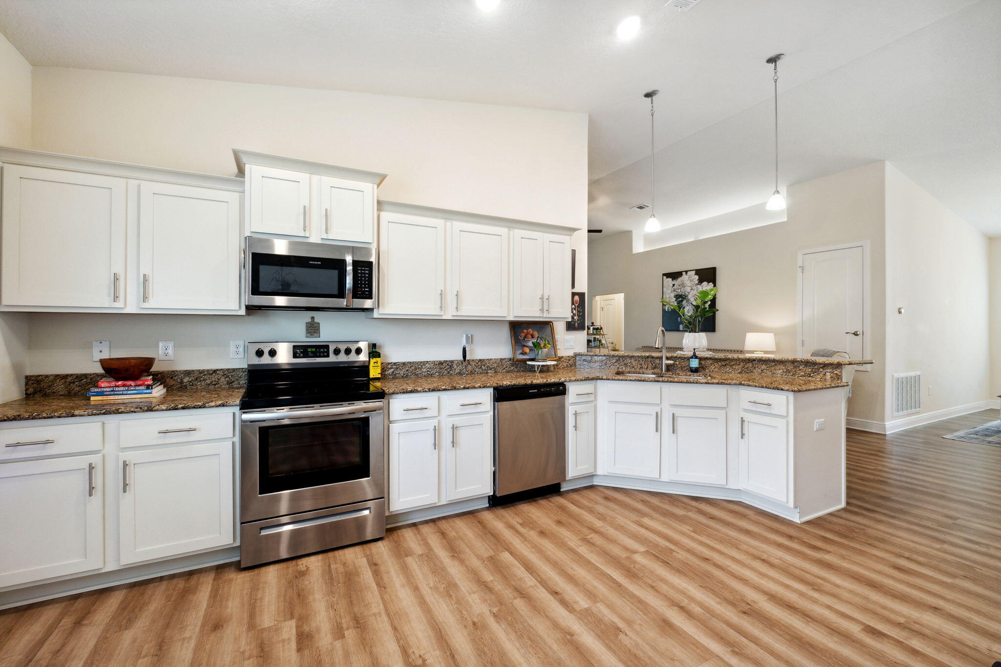 585 Riverwalk Circle Freeport, FL 32439 - Photo 11 of 36 a kitchen with stainless steel appliances granite countertop a stove a sink and a microwave