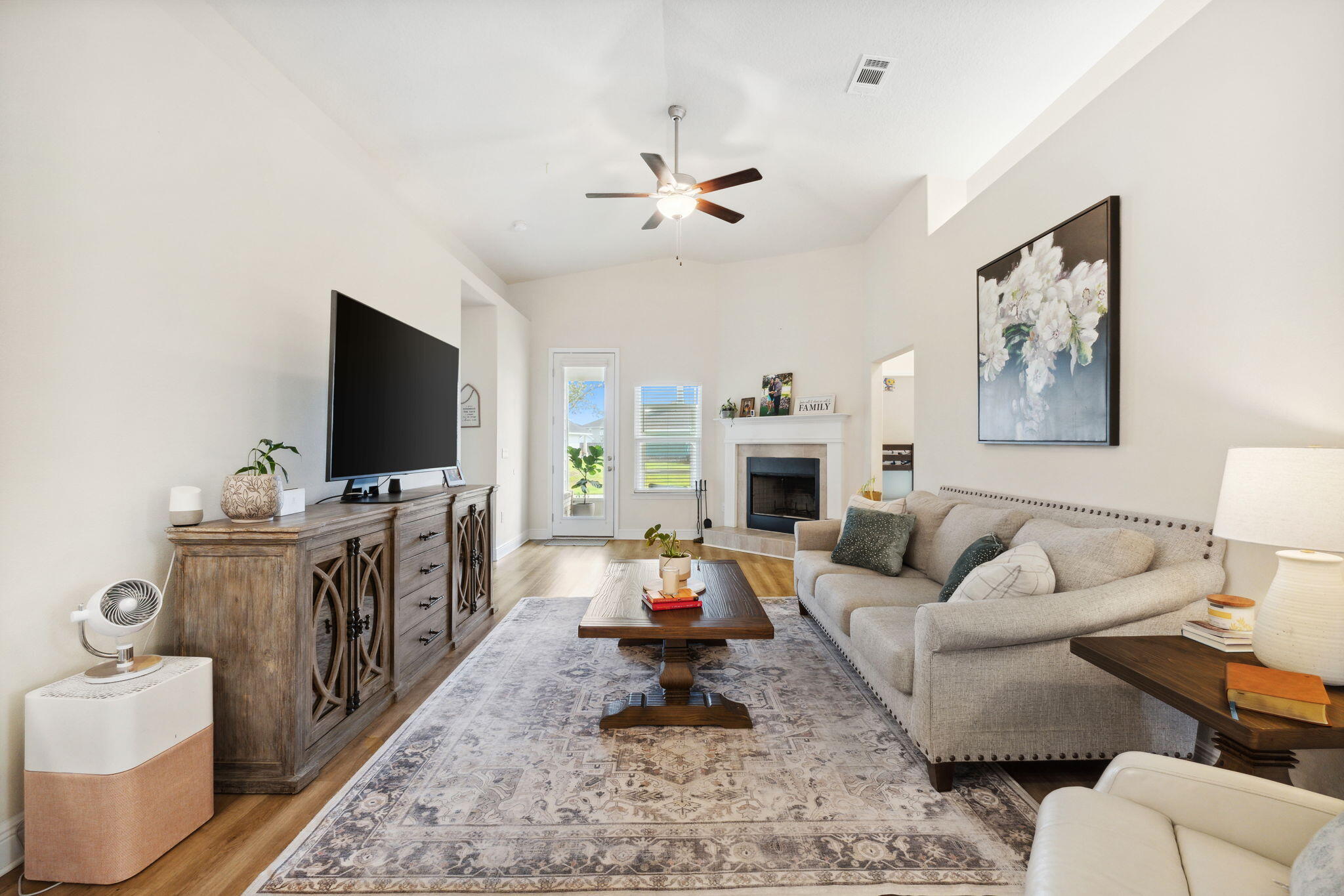 585 Riverwalk Circle Freeport, FL 32439 - Photo 21 of 36 a living room with furniture a flat screen tv and a fireplace