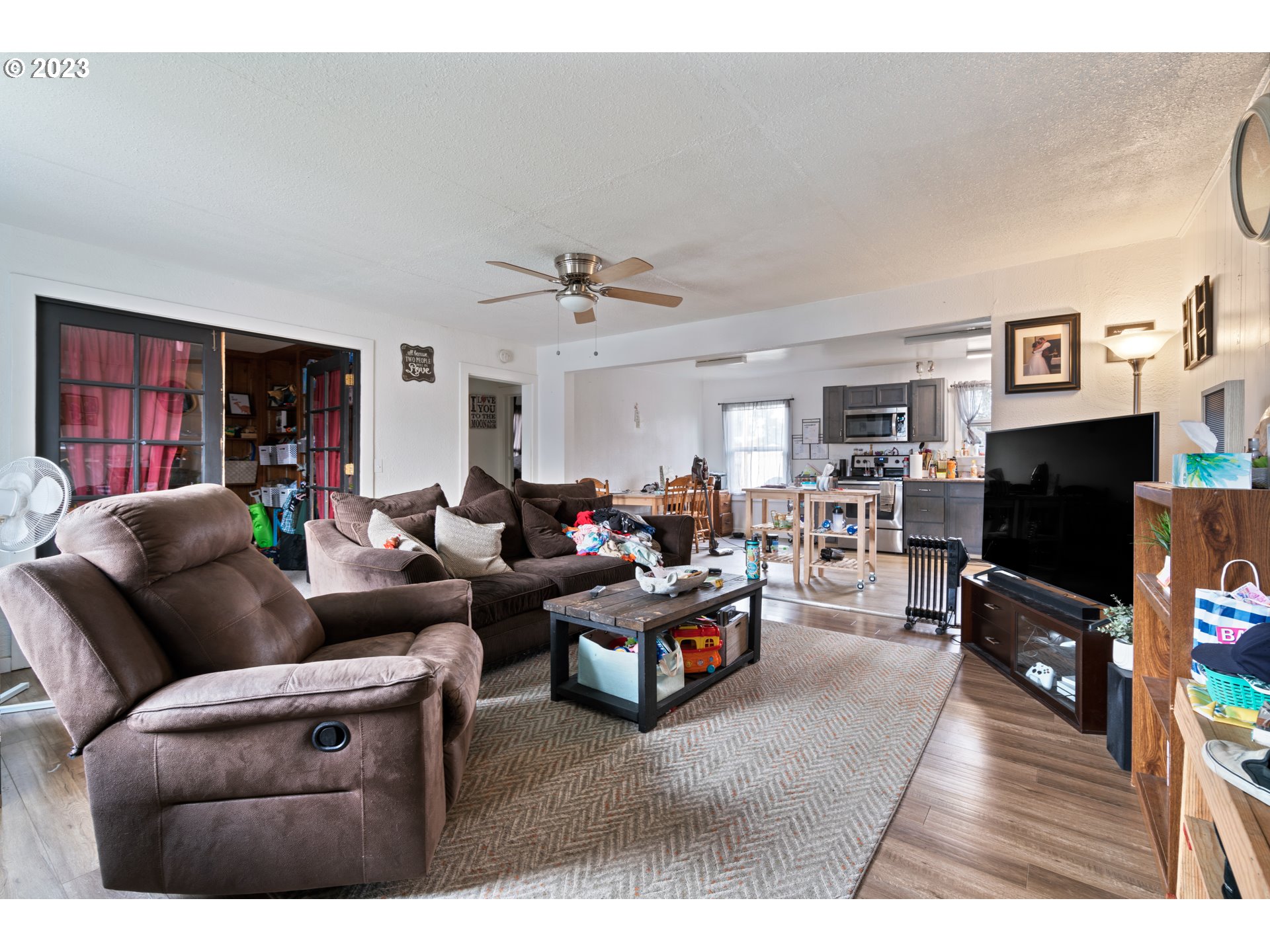 2380 E Street Springfield, OR 97477 - Photo 3 of 13 a living room with furniture a flat screen tv and kitchen view