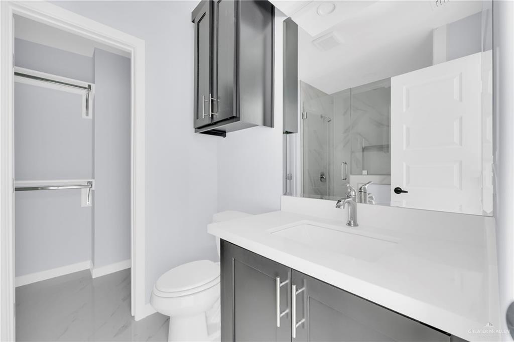 1612 Shadow Creek, Unit 4 Weslaco, TX 78599 - Photo 12 of 14 a bathroom with a sink a toilet and a mirror