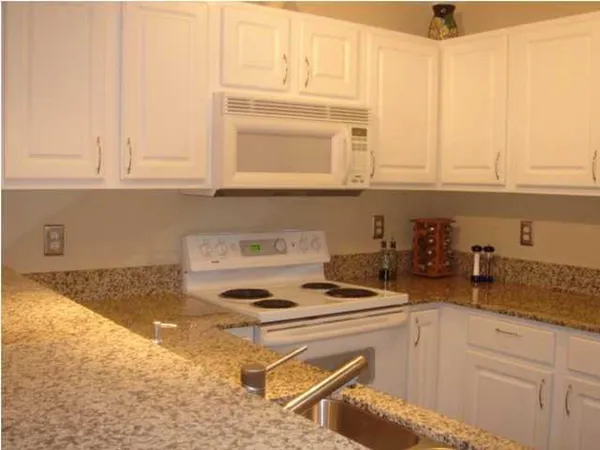 a kitchen with a stove a sink and a white cabinets