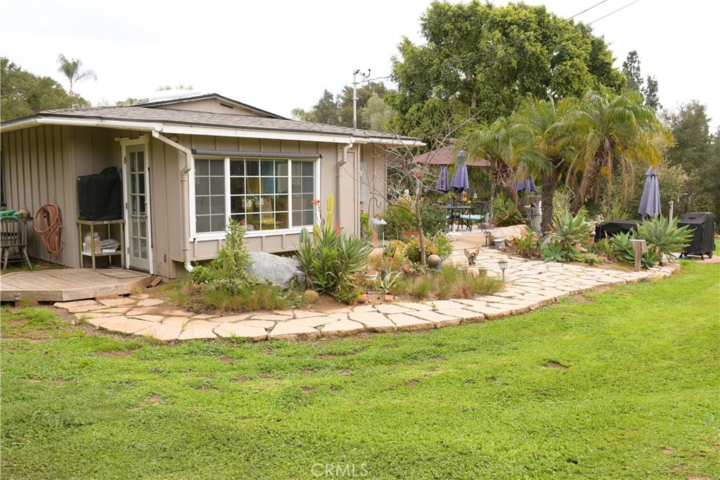 1256 East Fallbrook Street Fallbrook, CA 92028 - Photo 3 of 59 a front view of a house with a yard patio and fire pit