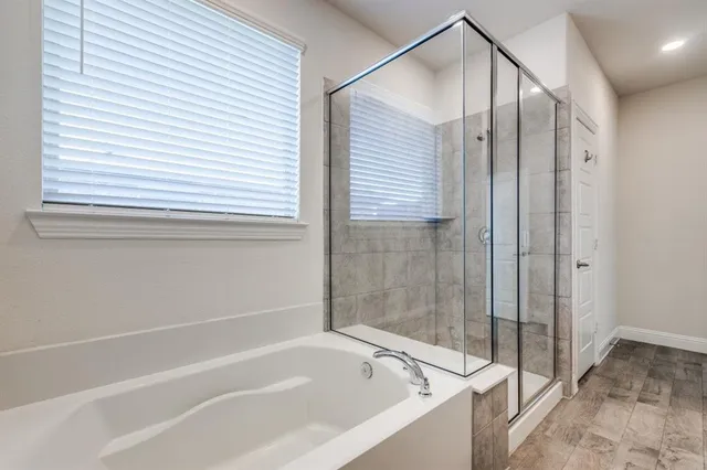 a bathroom with a toilet a sink a mirror a bathtub and shower