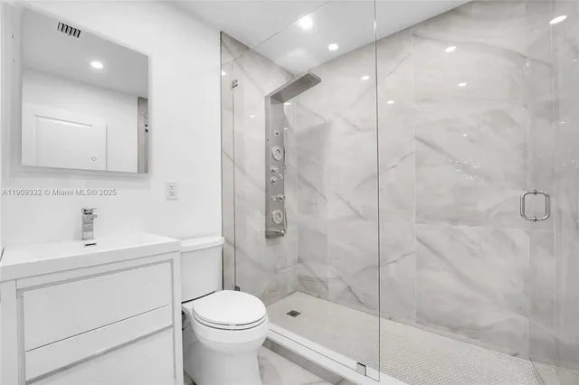 a bathroom with a sink a toilet and shower