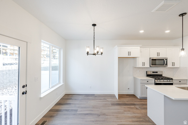 4775 Olive Avenue, Unit 412 Mapleton, UT 84664 - Photo 6 of 19 Kitchen with white cabinetry, stainless steel appliances, suspended lighting, and light wood-style floors