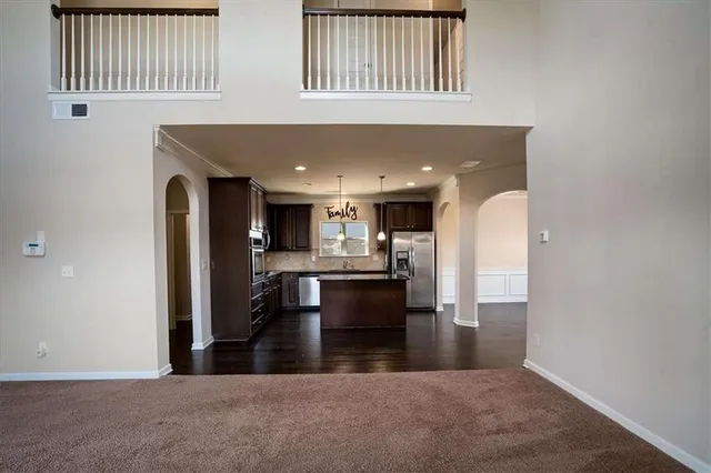 a view of kitchen with kitchen island stainless steel appliances sink refrigerator and window