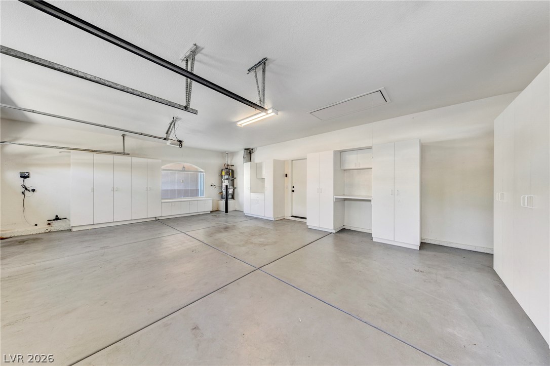 740 Aldo Rae Court, Unit NONE Henderson, NV 89052 - Photo 29 of 35 A capacious garage provides ample storage with integrated cabinetry and a neatly organized utility corner.