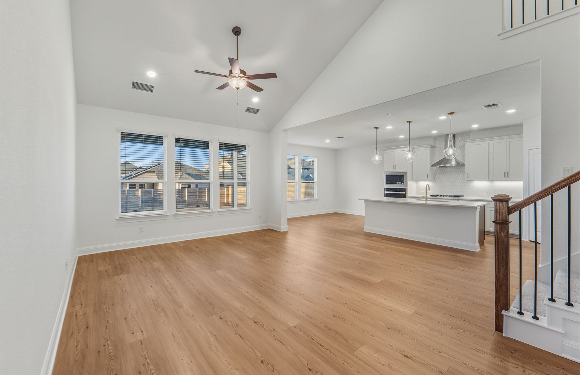 456 Foresail Road Leander, TX 78641 - Photo 7 of 22 a view of an empty room and kitchen view with wooden floor