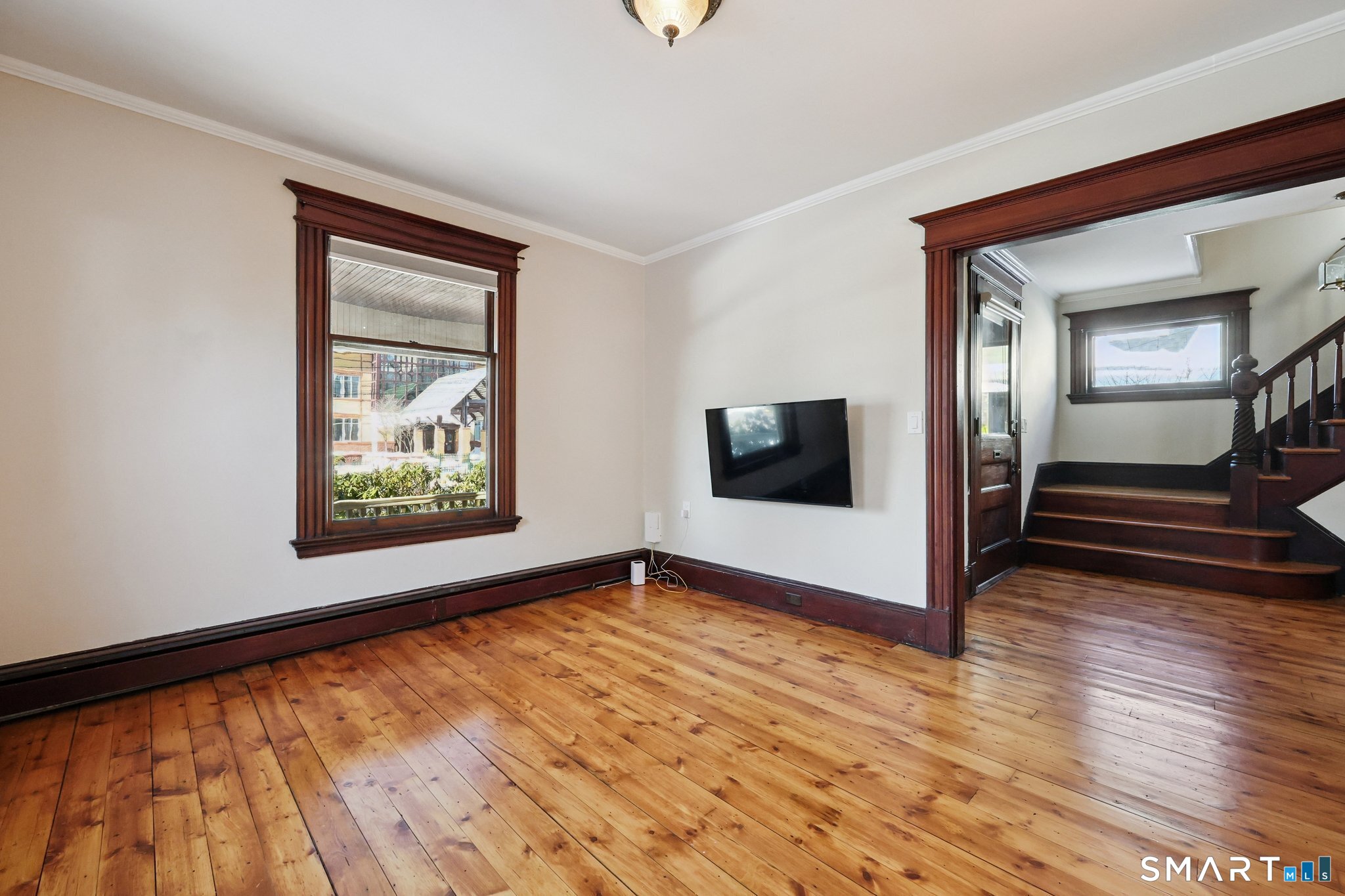 56 Whitney Street Hartford, CT 06105 - Photo 7 of 40 a view of an empty room with wooden floor and a window