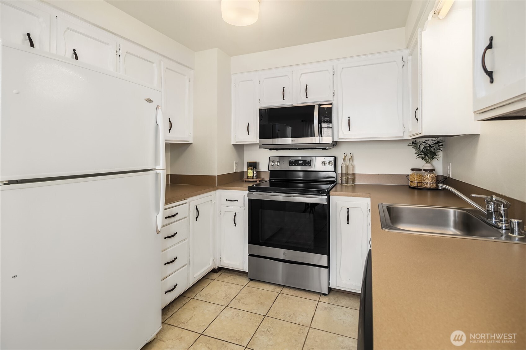 1612 33rd Street, Unit 104 Everett, WA 98201 - Photo 11 of 24 a kitchen with stainless steel appliances a refrigerator sink and white cabinets