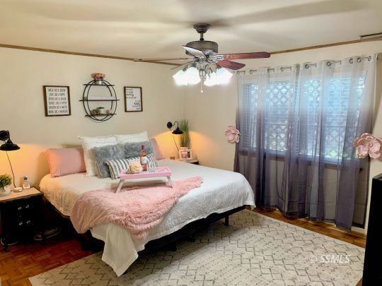 217 Rancho Street Ridgecrest, CA 93555 - Photo 17 of 25 a bedroom with a bed and a chandelier