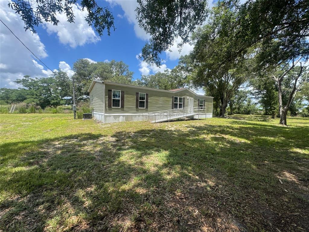 9827 Southeast Hoth Road Arcadia, FL 34266 - Photo 3 of 28 a front view of house with yard and trees