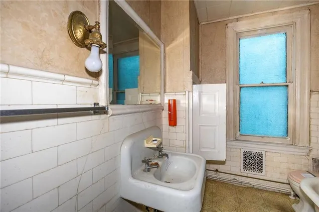a view of a livingroom with a chandelier fan and kitchen view