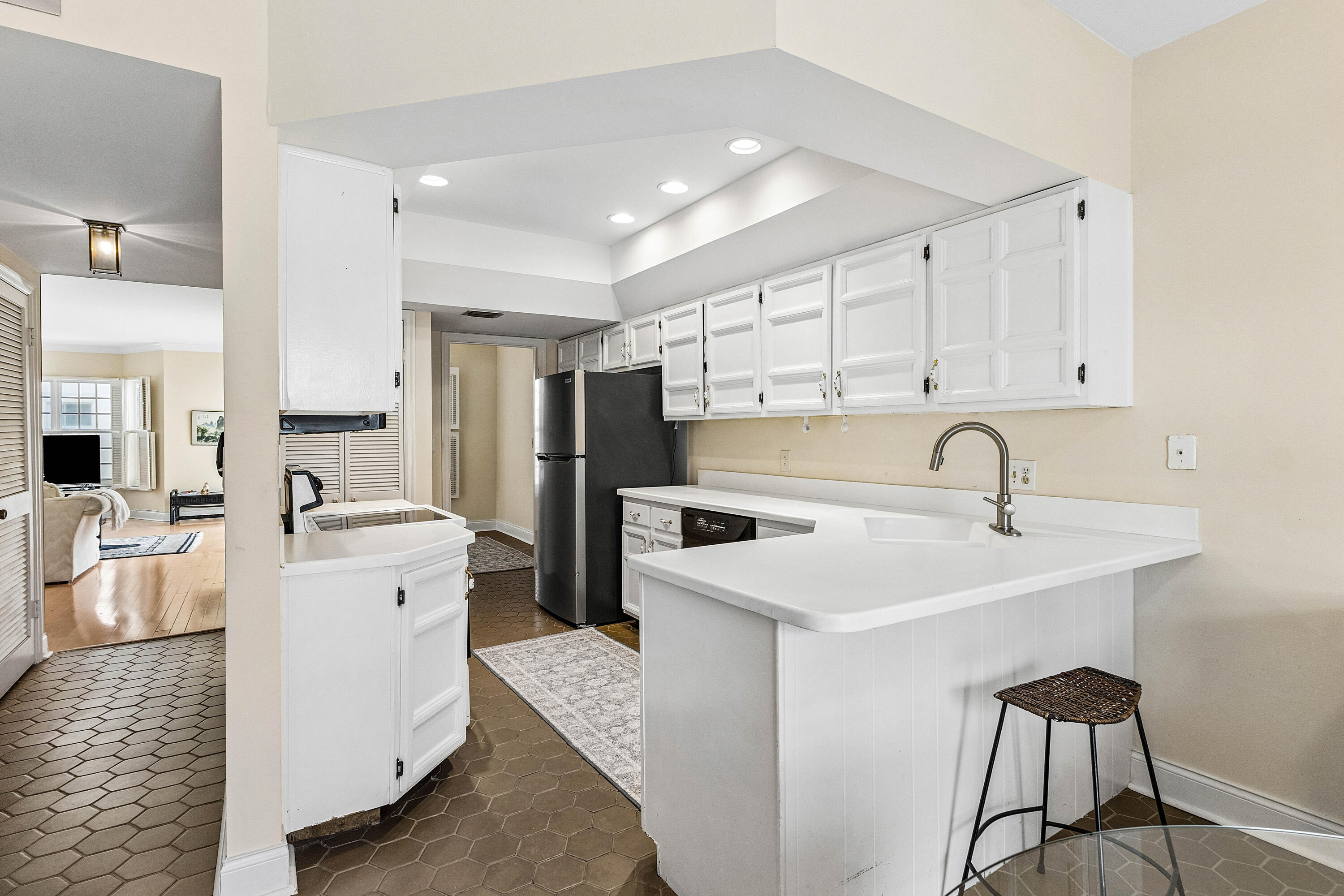 5900 Old Ocean Boulevard, Unit C5 Ocean Ridge, FL 33435 - Photo 4 of 17 a kitchen with white cabinets and stainless steel appliances