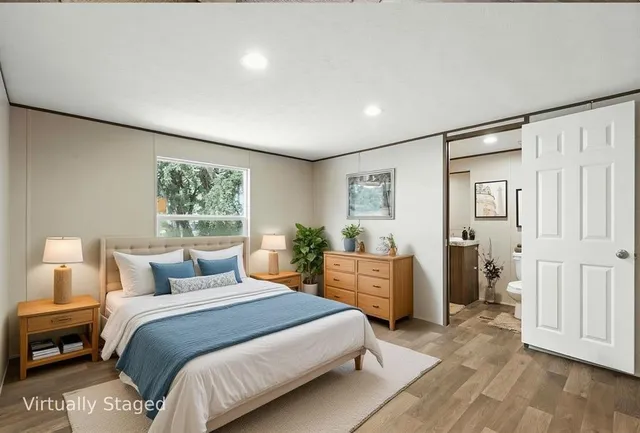 a bedroom with a large bed and wooden floor