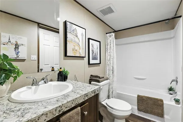 a bathroom with a granite countertop sink toilet and shower