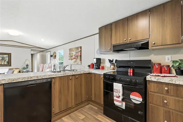 a kitchen with stainless steel appliances granite countertop a sink dishwasher stove and cabinets