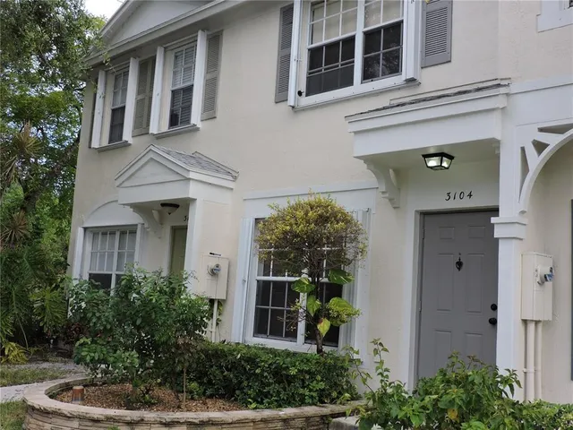 a front view of a house with plants