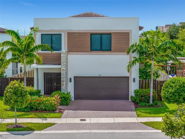 a front view of a house with a yard and potted plants
