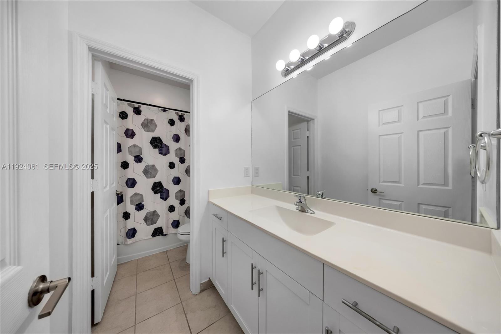 268 Northeast 210th Way Miami, FL 33179 - Photo 35 of 98 a spacious bathroom with a shower a sink and a mirror