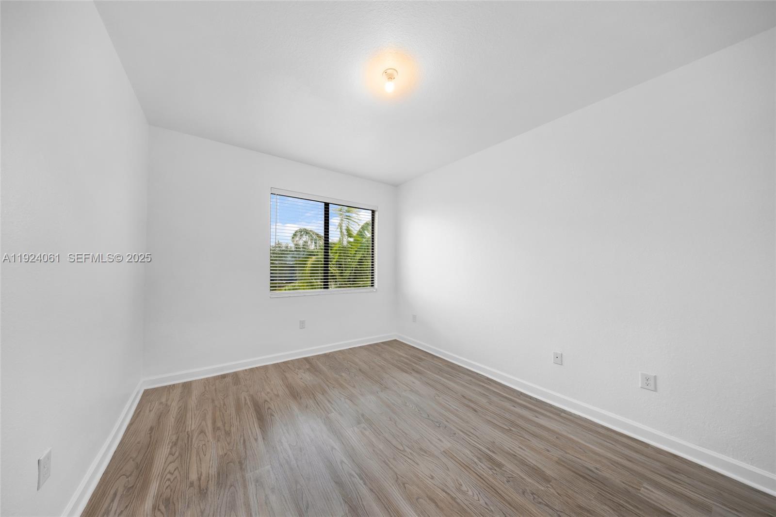 268 Northeast 210th Way Miami, FL 33179 - Photo 47 of 98 an empty room with wooden floor and windows