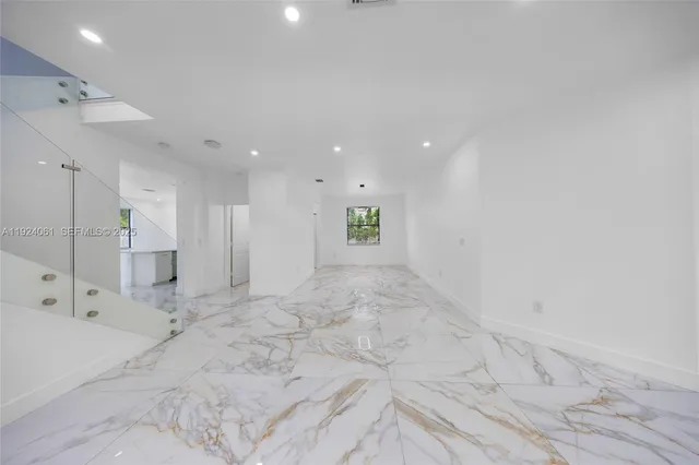 a large white kitchen with granite countertop a large window and a sink