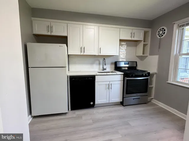a kitchen with a sink a stove and a refrigerator