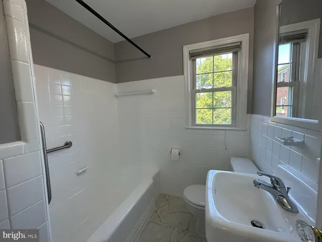 a bathroom with a sink a window and shower