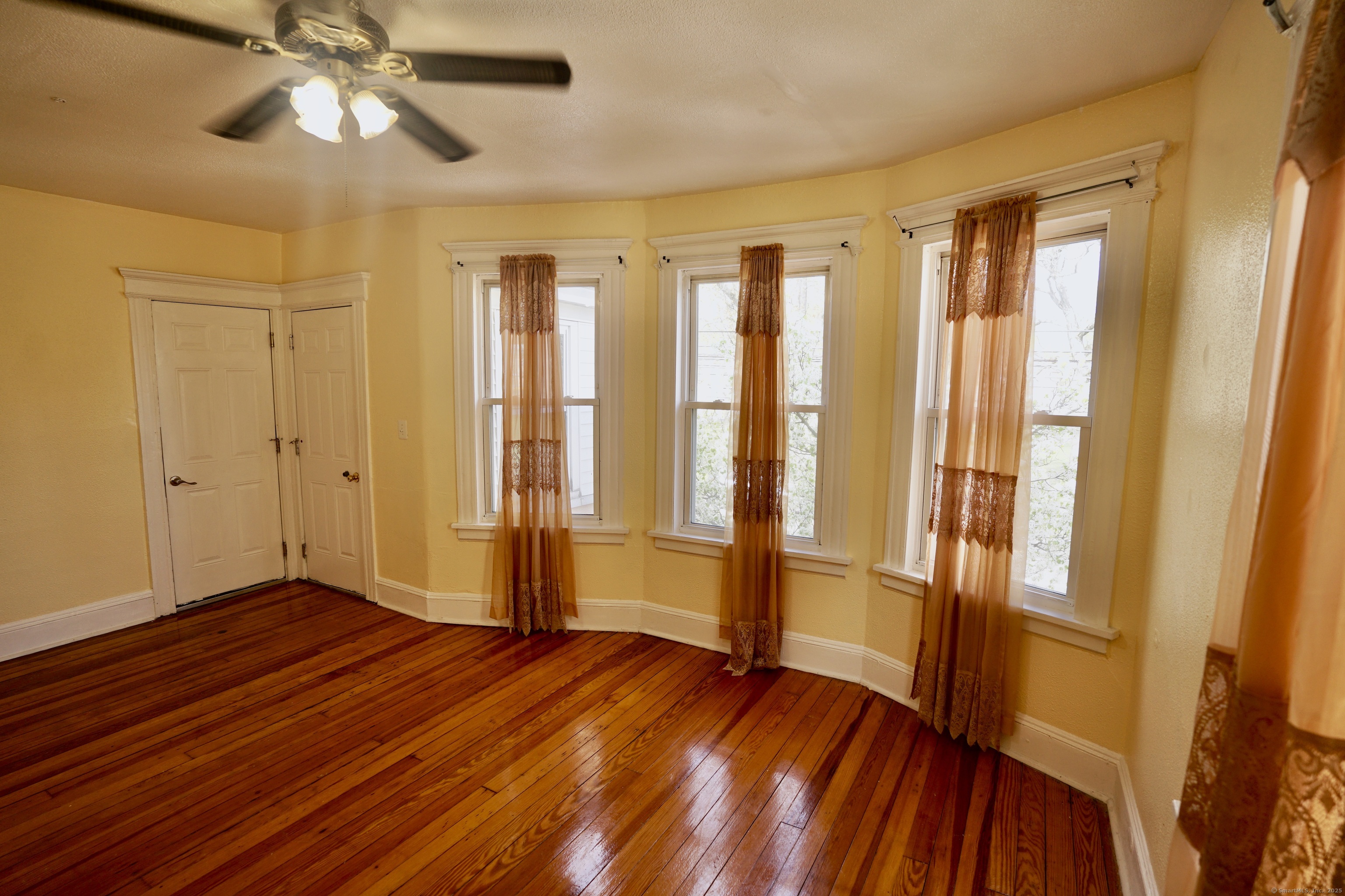 744 Boston Avenue Bridgeport, CT 06610 - Photo 2 of 10 wooden floor in an empty room with a window