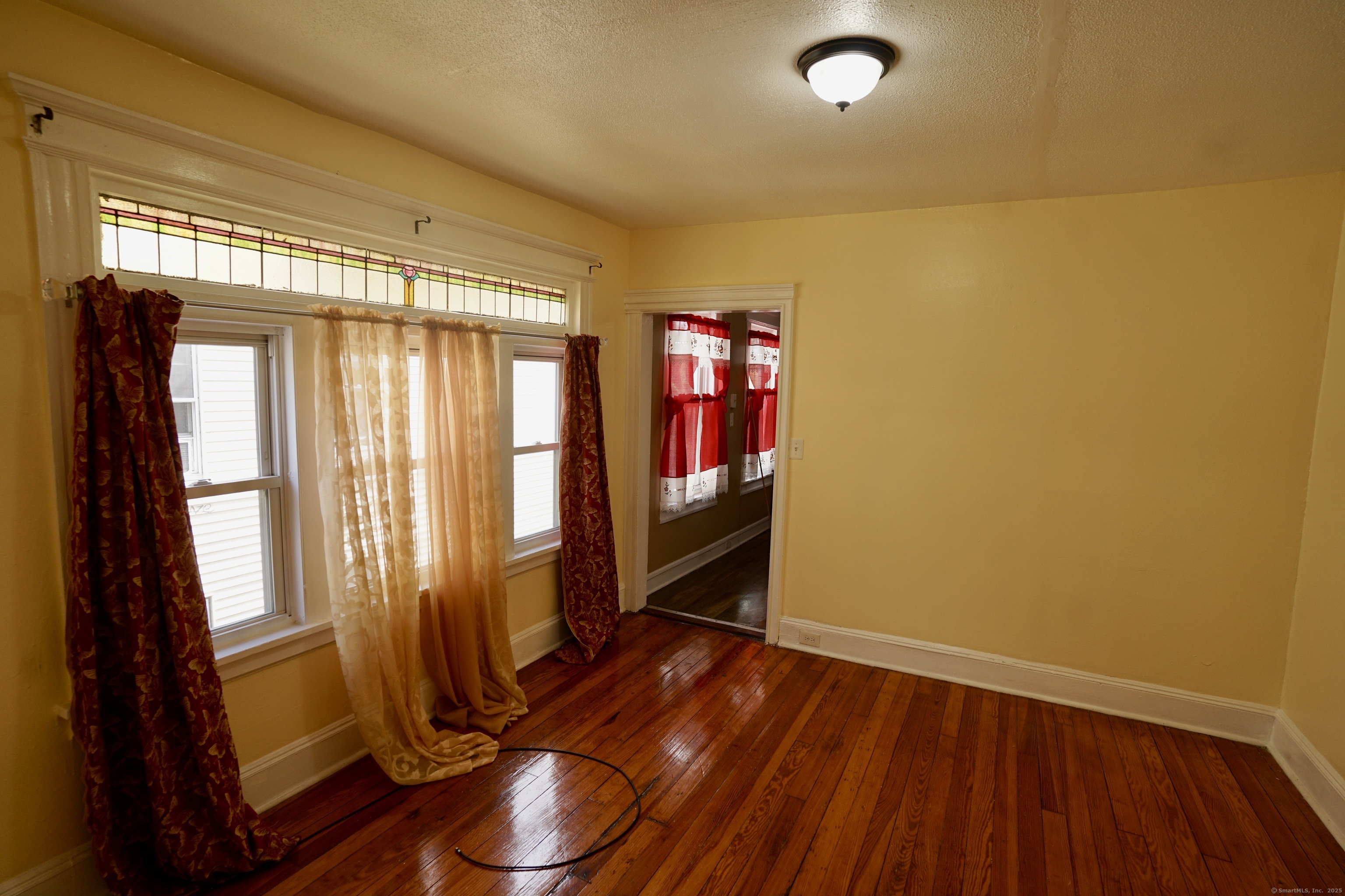 744 Boston Avenue Bridgeport, CT 06610 - Photo 3 of 10 a view of empty room with wooden floor and fan