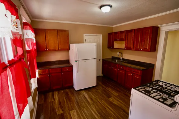 a kitchen with a refrigerator stove and wooden cabinets
