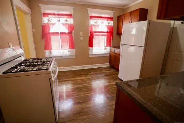 a kitchen with stainless steel appliances a refrigerator sink and wooden floor