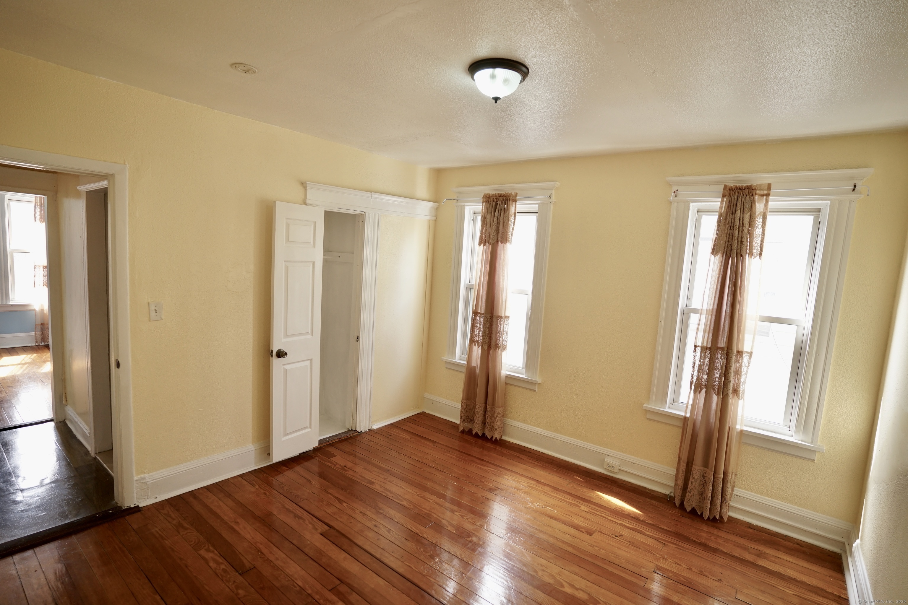 744 Boston Avenue Bridgeport, CT 06610 - Photo 9 of 10 an empty room with wooden floor and windows