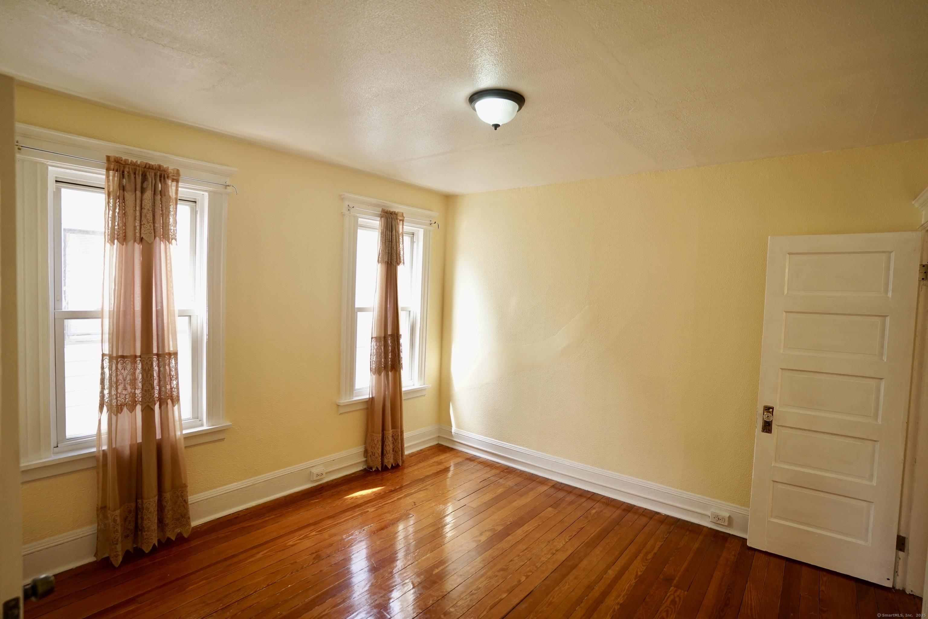 744 Boston Avenue Bridgeport, CT 06610 - Photo 10 of 10 a view of an empty room with wooden floor and a window
