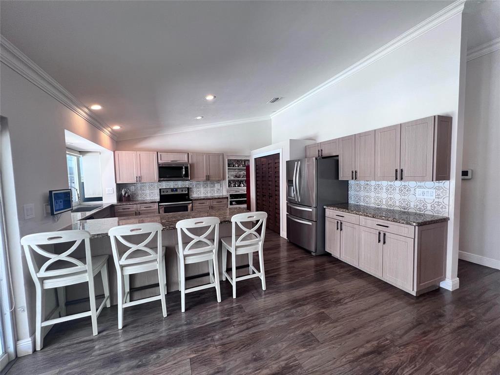 3300 Bridge Road Cooper City, FL 33026 - Photo 2 of 30 a large kitchen with kitchen island wooden floors white cabinets and stainless steel appliances
