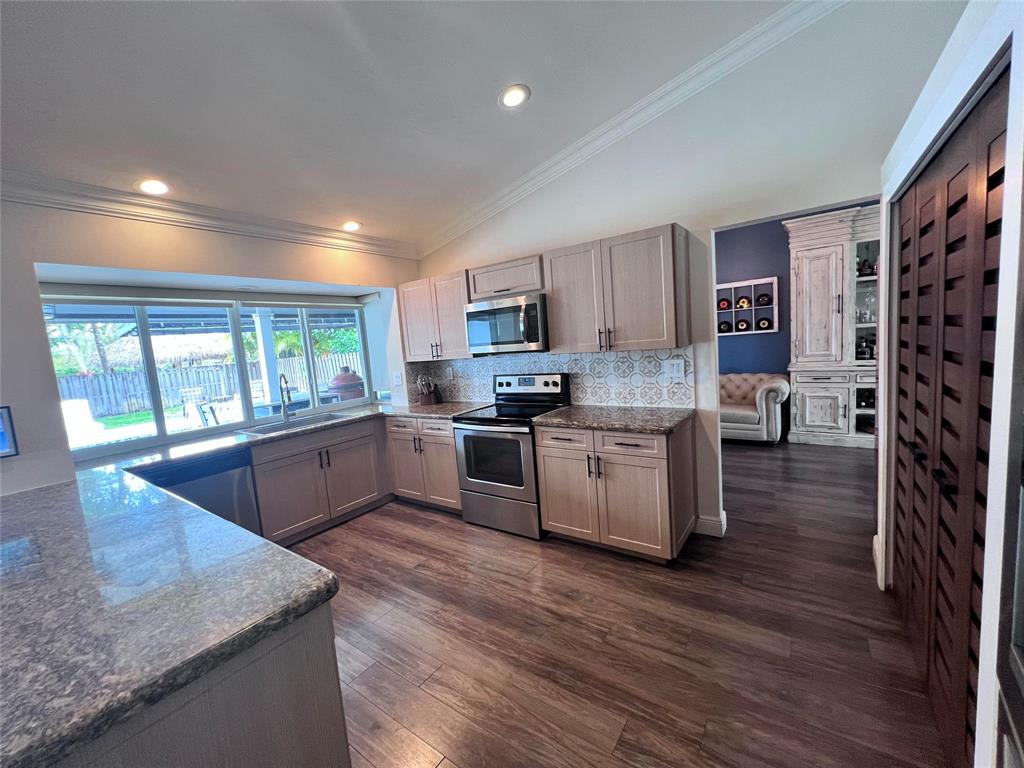 3300 Bridge Road Cooper City, FL 33026 - Photo 3 of 30 a kitchen with stainless steel appliances granite countertop a stove a sink and a refrigerator