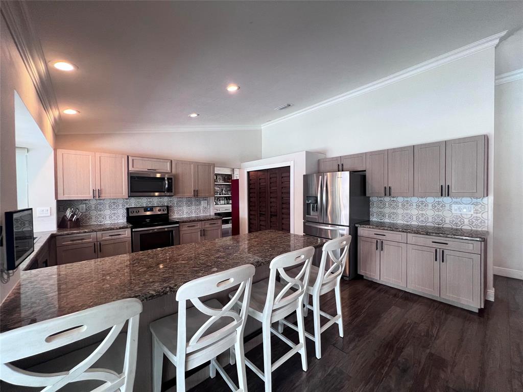 3300 Bridge Road Cooper City, FL 33026 - Photo 4 of 30 a kitchen with stainless steel appliances granite countertop a kitchen island hardwood floor sink stove dining table and chairs