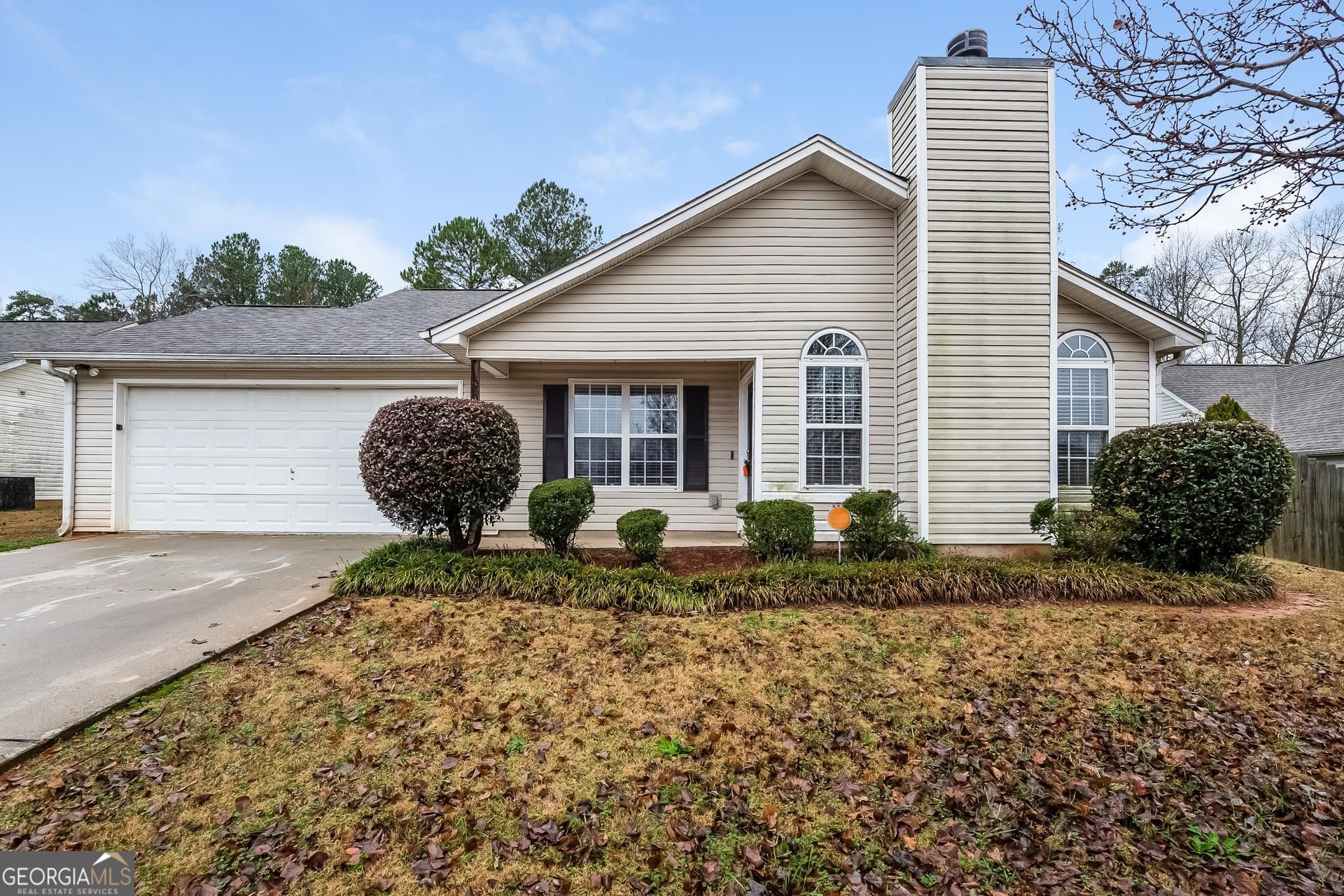 a front view of house with backyard and trees