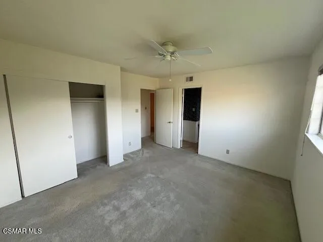 an empty room with a window and a ceiling fan