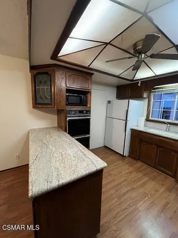 a kitchen with a wooden floor and a refrigerator