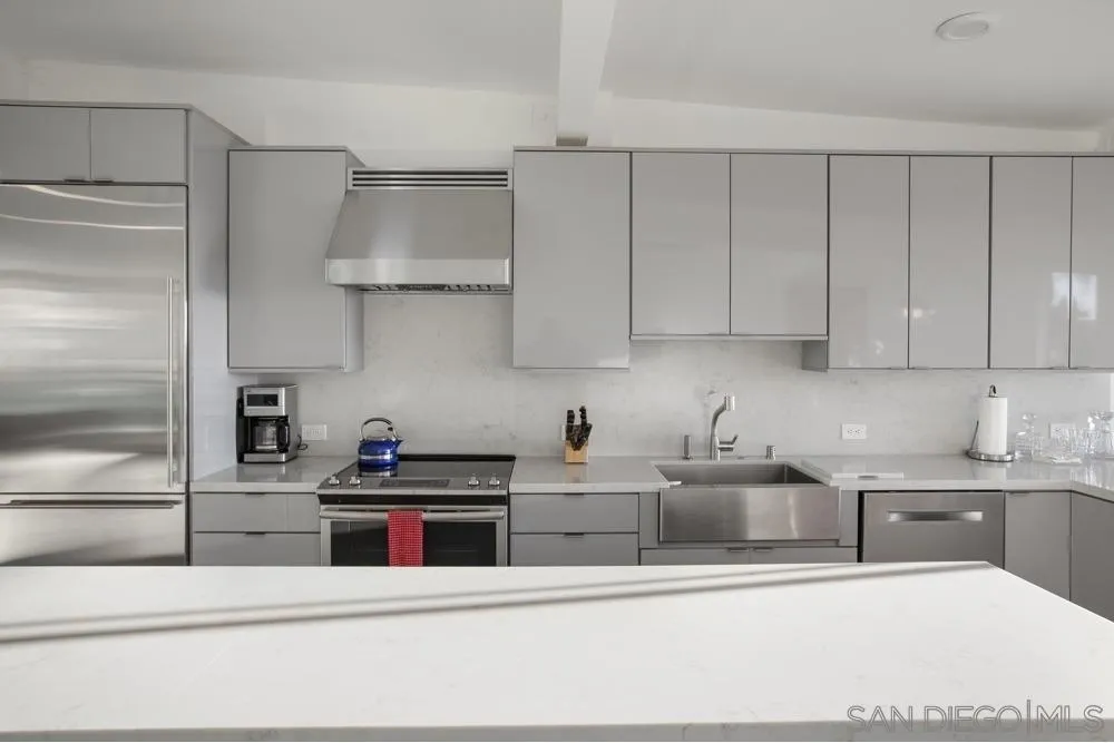 2331 Caringa Way, Unit 38 Carlsbad, CA 92009 - Photo 6 of 26 a kitchen with stainless steel appliances granite countertop a sink a stove and a refrigerator