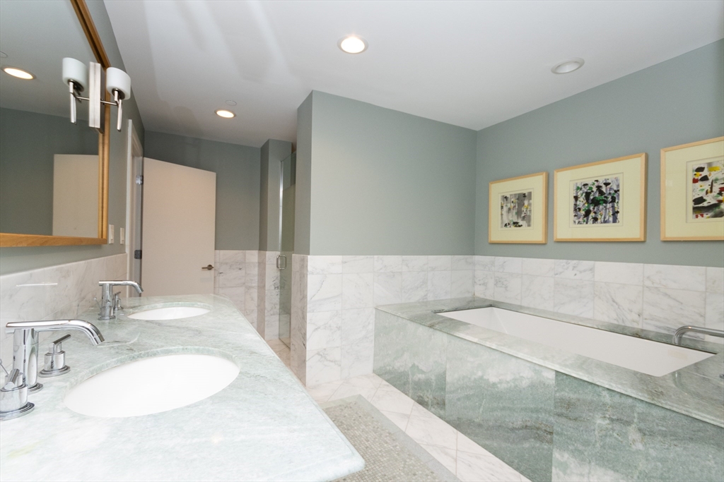 241 Perkins Street, Unit D302 Boston, MA 02130 - Photo 22 of 31 a spacious bathroom with a granite countertop sink and a large mirror